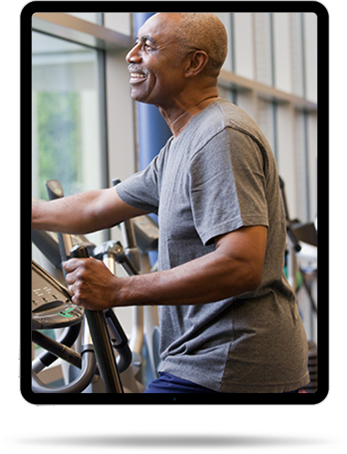 Senior man exercising in a gym on an elliptical machine